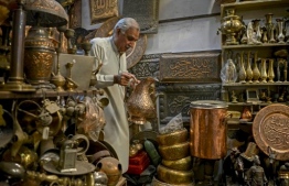 In this picture taken on October 28, 2020, local resident Khwaja Safar Ali, 75, arranges items in his antiques shop at the oldest Qissa Khawani or "storytellers bazaar" in Pakistan's northwestern city of Peshawar. - The city of Peshawar -- in Khyber Pakhtunkhwa province where Shogran is located -- has long been the countryís stronghold of oral history, its Qissa Khawani or "storytellers bazaar" a Silk Road hub where travellers and locals alike congregated to hear a well-spun yarn. (Photo by Abdul MAJEED / AFP) / 