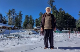 In this picture taken on November 21, 2020, Mohammad Naseem poses for a photograph in the Shogran hill area in Kaghan Valley, northern Pakistan. - Mohammad Naseem's eyes shine while he shares the legend of a remote, alpine lake nestled among snow-capped Himalayan peaks as a rare crowd of onlookers hears one of Pakistan's last "storytellers". (Photo by Joris FIORITI / AFP) /