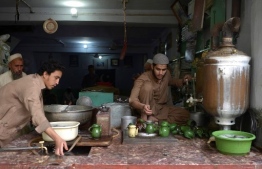 In this picture taken on October 28, 2020, a man prepares traditional tea for customers at the oldest Qissa Khawani or "storytellers bazaar" in Pakistan's northwestern city of Peshawar. - The city of Peshawar -- in Khyber Pakhtunkhwa province where Shogran is located -- has long been the countryís stronghold of oral history, its Qissa Khawani or "storytellers bazaar" a Silk Road hub where travellers and locals alike congregated to hear a well-spun yarn. (Photo by Abdul MAJEED / AFP) /