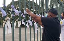 Sri Lankans tie white fabric outside a crematorium in Colombo, Sri Lanka as a sign of protest over the forced cremations of Muslims that die of COVID19; Islamic burial rites forbid cremation of bodies. PHOTO: AFP