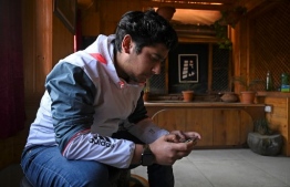 In this picture taken on November 20, 2020, Zeyan Shafiq plays the PUBG mobile game in Srinagar. - When India banned the hit PUBG mobile game over its diplomatic row with China, Zeyan Shafiq's eSports team was suddenly left without players. So Shafiq, who is based in war-torn Kashmir, did something very unusual: he reached across the border to Pakistan. (Photo by Tauseef MUSTAFA / AFP) /