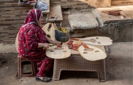 A woman works on Arabian Ouds at a workshop belonging to Khaled Azzouz, a veteran oud-maker at the al-Marg district on the outskirts of the Egyptian capital Cairo on October 26, 2020. - The oud, a centuries-old stringed instrument popular in the Middle East, is a key element of classical Arabic music. Azzouz said he had observed "unprecedented interest" in the out during the global health pandemic. (Photo by Khaled DESOUKI / AFP)