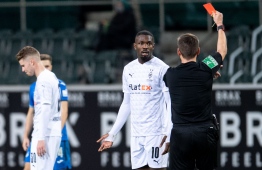 (FILES) In this file photo taken on December 19, 2020 Referee Frank Willenborg shows Moenchengladbach's French forward Marcus Thuram the red card during the German first division Bundesliga football match Borussia Moenchengladbach v TSG 1899 Hoffenheim in Moenchengladbach. - Marcus Thuram will be suspended for six matches after spitting in the face of  Hoffenheim's Stefan Posch, the German football Federation announced on December 21, 2020. (Photo by Marius Becker / POOL / AFP)