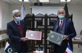Secretary Ministry of Economic Affairs of Pakistan, Noor Ahmed (L) and Yves Manville (R), Deputy Head of Mission of the French embassy to Pakistan, exchange agreement copies of the G20 Debt Service Suspension Initiative (DSSI), in Islamabad on December 21, 2020.   
Farooq NAEEM / AFP