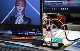 This photo taken on November 12, 2020 shows a cutout of virtual idol Amy on the desk of an animator at the Beijing Mizhi Tech offices in Beijing. - Although the virtual idol concept originated in Japan, these digital avatars are now stealing airtime in China, where they appear on TV shows, billboards and even news programmes. (Photo by GREG BAKER / AFP) / To go with AFP story China-technology-entertainment, FOCUS by Helen ROXBURGH with Danni ZHU