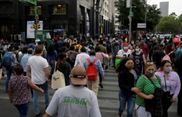 (FILES) In this file photo taken on December 16, 2020 People walk in downtown in Mexico City on December 16, 2020, amid the COVID-19 pandemic. - Mexico recorded on December 22, 2020 another record of daily covid-19 contagions with 12.511 people infected, in moments in which the capital city is under maximum health alert with restriction of economic activities to reduce the spread of the virus and hospital occupancy. (Photo by ALFREDO ESTRELLA / AE / AFP)