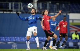 Everton's Portuguese midfielder Andre Gomes (L) controls the ball in front of Manchester United's Uruguayan striker Edinson Cavani (C) during the English League Cup quarter final football match between Everton and Manchester United at Goodison Park in Liverpool on December 23, 2020. (Photo by Nick Potts / POOL / AFP)