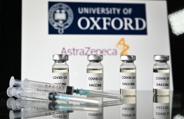 (FILES) In this file photo taken on November 17, 2020 An illustration picture shows vials with Covid-19 Vaccine stickers attached and syringes, with the logo of the University of Oxford and its partner British pharmaceutical company AstraZeneca. (Photo by JUSTIN TALLIS / AFP)