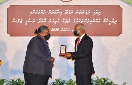 President Ibrahim Mohamed Solih presents the National Award to Ibrahim Waheed. PHOTO: MIHAARU