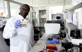 (FILES) In this file photo taken on June 02, 2020 Professor Christian Happi, the director of African Centre of Excellence for Genomics of Infectious Diseases (ACEGID), holds a minipcr thermal cycler, a laboratory apparatus used to amplify segments of DNA during an inspection of facilities at the centre located at the Redeemerís University in Ede, southwestern Nigeria. - A new strain of coronavirus, still different from the one found recently in South Africa and England, but which "shares some mutations with the one discovered in the United Kingdom" has been discovered in Nigeria, the most populous country in Africa with 200 million inhabitants. 
Following this discreet announcement, made this week by the African Centre of Excellence for Genomics and Infectious Diseases Research (Acegid), based in Ede, south-west Nigeria, the African Union's health agency, the African Centre for Disease Control and Prevention (CDC), held an emergency meeting. 
But Professor Christian Happi, the molecular biologist behind the genetic sequencing of this new variant, called for this new discovery not to be "extrapolated", in an interview with AFP. (Photo by PIUS UTOMI EKPEI / AFP)