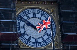 A Union flag flutters in the breeze in front of the clock face of the Elizabeth Tower, known after the bell Big Ben, in central London on December 30, 2020. - Members of the British parliament were set to debate and vote on legislation on the UK's future relationship with the EU as EU leaders signed their post-Brexit trade deal with Britain and dispatched it to London on an RAF jet, setting their seal on a drawn-out divorce. (Photo by JUSTIN TALLIS / AFP)