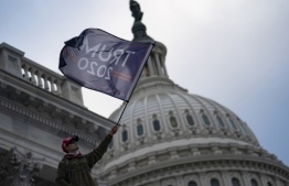 A person waves a Trump 2020 flag as supporters of US President Donald Trump protest outside the US Capitol on January 6, 2021, in Washington, DC. - Demonstrators breeched security and entered the Capitol as Congress debated the a 2020 presidential election Electoral Vote Certification. (Photo by ALEX EDELMAN / AFP)