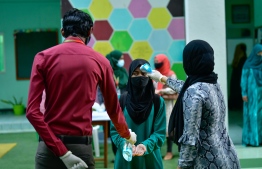 A student sanitising their hands and getting their temperature checked at the school gate. PHOTO: MIHAARU