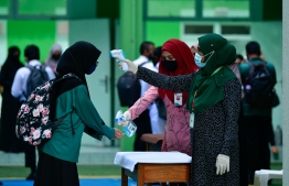 Students getting their temperature checked at the school gate on the first day of the new academic year. PHOTO: MIHAARU