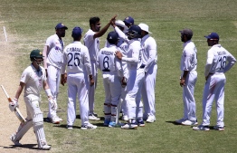 India's Ravichandran Ashwin (4L) celebrates with teammates after taking the wicket of Australia's Steven Smith (L) on the fourth day of the third cricket Test match between Australia and India at the Sydney Cricket Ground (SCG) in Sydney on January 10, 2021. (Photo by DAVID GRAY / AFP) / 