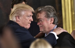 (FILES) In this file photo taken on January 22, 2017 US President Donald Trump (L) congratulates Senior Counselor to the President Stephen Bannon during the swearing-in of senior staff in the East Room of the White House in Washington, DC. - President Donald Trump has decided to pardon his influential former adviser Steve Bannon, US media reported January 19, 2021, though no official announcement had been made as Trump counted down his final hours in the White House. Bannon was granted clemency after being charged with defrauding people over funds raised to build the Mexico border wall that was a flagship Trump policy, the New York Times said citing White House officials. (Photo by MANDEL NGAN / AFP)