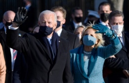 US President Joe Biden and First Lady Jill Biden walk up Pennsylvania Avenue towards the White House in Washington, DC, after Biden and Kamala Harris were sworn in at the US Capitol on January 20, 2021. (Photo by MANDEL NGAN / AFP)