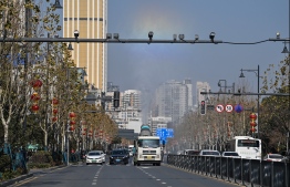 This photo taken on January 19, 2021 shows traffic along a street in Wuhan in China's central Hubei province. - January 23 marks one year since the start of a 76-day lockdown of Wuhan, the central Chinese city where the coronavirus was first detected before sweeping across the world and killing more than two million people. (Photo by Hector RETAMAL / AFP)