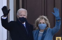 US President Joe Biden and First Lady Jill Biden wave as they arrive at the White House in Washington, DC, on January 20, 2021. (Photo by Patrick T. FALLON / AFP)