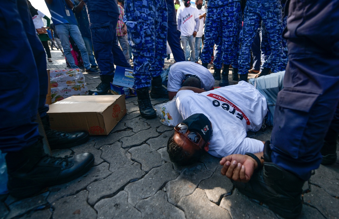 މާލެ: ޖެނުއަރީ 21، 2021- ކުރީގެ ރައީސް އަބްދުﷲ ޔާމީން ޖަލަށް ލުމަށް ކްރިމިނަލް ކޯޓުން ކޮށްފައިވާ ހުކުމް އިސްތިއުނާފު ކުރުމުން ހައި ކޯޓުން ގޮތެއް ނިންމުމަށް ބޭއްވި ޝަރީއަތުގެ އަޑުއެހުން ކުރިޔަށް ގެންދިޔަ ވަގުތު އެ ސަރަހައްދަށް އެއްވި އިދިކޮޅު ސަޕޯޓަރުން ކޮންޓްރޯލް ކުރުމަށް ފުލުހުން މަސައްކަތް ކުރި ވަގުތު މީހަކު ވެއްޓިފައި.---ފޮޓޯ: ނިޝާން އަލީ/މިހާރު