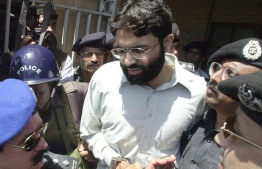(FILES) In this file taken on March 29, 2002, police escort British-born Ahmed Omar Saeed Sheikh out of a court in Karachi. Pakistan's Supreme Court on January 28, 2021, dismissed a series of appeals against the acquittal of the British-born militant convicted of masterminding the kidnap and murder of US journalist Daniel Pearl, paving the way for his release. Aamir QURESHI / AFP
