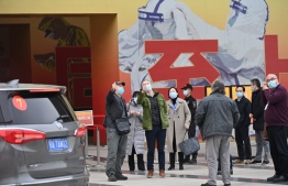 Members of the World Health Organization (WHO) team investigating the origins of the Covid-19 pandemic arrive to visit a museum exhibition about China's fight against Covid-19 in Wuhan, China's central Hubei province on January 30, 2021. (Photo by HECTOR RETAMAL / AFP)