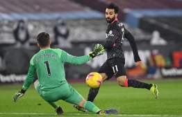 Liverpool's Egyptian midfielder Mohamed Salah (R) shoots past West Ham United's Polish goalkeeper Lukasz Fabianski (L) to score their second goal during the English Premier League football match between West Ham United and Liverpool at The London Stadium, in east London on January 31, 2021. (Photo by Justin Setterfield / POOL / AFP) / RESTRICTED TO EDITORIAL USE. No use with unauthorized audio, video, data, fixture lists, club/league logos or 'live' services. Online in-match use limited to 120 images. An additional 40 images may be used in extra time. No video emulation. Social media in-match use limited to 120 images. An additional 40 images may be used in extra time. No use in betting publications, games or single club/league/player publications. / 