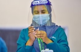 A health worker prepares to administer a dose of the COVISHIELD vaccine during the first day of Maldives' vaccination programme. PHOTO: AHMED AWSHAN ILYAS/ MIHAARU