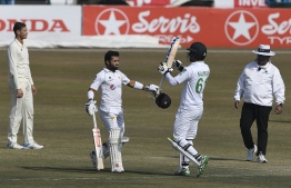 Pakistan's Mohammad Rizwan (2L) celebrates teammate Nauman Ali (2R) after scoring a century (100 runs) during the fourth day of the second Test cricket match between Pakistan and South Africa at the Rawalpindi Cricket Stadium in Rawalpindi on February 7, 2021. (Photo by Aamir QURESHI / AFP)