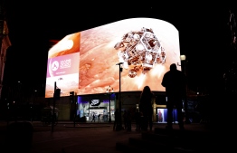 An image showing the simulation of the landing of NASA's Perseverance rover on the planet Mars, where it will look for signs of past microbial life, cache rock and soil samples, and prepare for future human exploration, is livestreamed on the Piccadilly Lights screen in central London, on February 18, 2021. (Photo by Tolga Akmen / AFP)