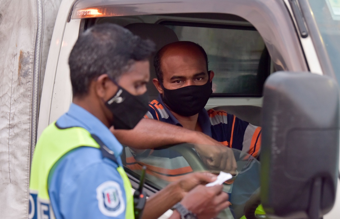 ފެބުރުއަރީ 20، 2021- ކޮވިޑް ޖެހޭ މީހުންގެ އަދަދު ރާއްޖޭގައި އިތުރުވުމާ ގުޅިގެން އެޗުޕީއޭއިން މާލެ ސަރަހައްދުގައި ހަވީރު 6 އިން ހެނދުނު 6 އަށް އެއްގަމު އުޅަނދު ދުއްވުން މަނާ ކުރުމާއެކު ހަވީރު ހައެއް ޖެހުމުގެ ކުރިން ޕިކަޕެއްގައި ބްރިޖު ހުރަސްކުރާ މީހަކާ ފުލުހަކު ވާހަކަ ދައްކަނީ.--- ފޮޓޯ: ނިޝާން އަލީ/މިހާރު