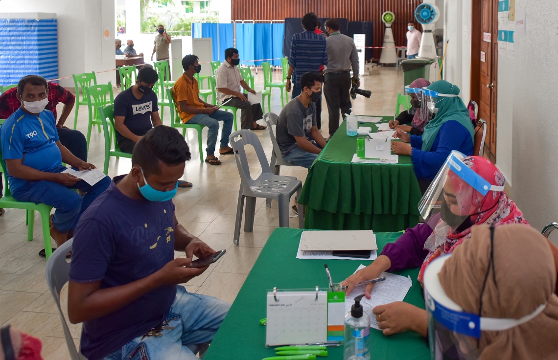 މާލެ: ފެބްރުއަރީ 25، 2021: ލިޔެކިޔުންނެތް ބިދޭސީއެއް ވެކްސިން ޖެހުމުގެ ކުރިން ފުރަންޖެހޭ މައުލޫމާތު ފޯމު ފުރަނީ.-- ފޮޓޯ: އަހުމަދު އަވްޝަން އިލްޔާސް /މިހާރު