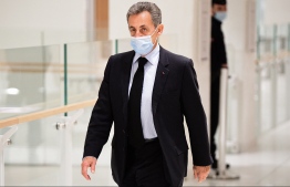 (FILES) In this file photo taken on December 8, 2020 Former French President Nicolas Sarkozy arrives for a hearing at his trial on corruption charges at Paris courthouse. - The Paris court on March 1, 2021 will rule on the fate of former French President Nicolas Sarkozy, against whom the prosecutor's office has requested prison for corruption and influence peddling. Four years in prison, including two years suspended, have been requested for the former head of state and his two co-defendants, his lawyer Thierry Herzog and former senior magistrate Gilbert Azibert. (Photo by Martin BUREAU / AFP)
