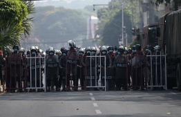 Riot police block a road during protests against the military coup in Yangon on February 26, 2021. (Photo by Ye Aung THU / AFP)