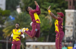 Fabian Allen (L) and Dwayne Bravo (R) of West Indies celebrate the dismissal of Danushka Gunathilaka of Sri Lanka during the 3rd and final T20i match between Sri Lanka and West Indies at Coolidge Cricket Ground on March 7, 2021 in Coolidge, Antigua and Barbuda. (Photo by Randy Brooks / AFP)