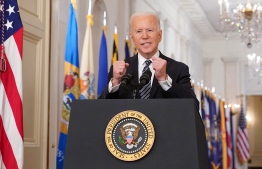 US President Joe Biden gestures as he speaks on the anniversary of the start of the Covid-19 pandemic, in the East Room of the White House in Washington, DC on March 11, 2021. (Photo by MANDEL NGAN / AFP)