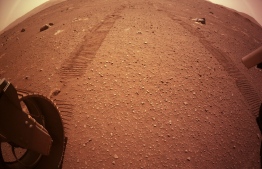 This handout photo released by NASA via NASA's Perseverance Mars Rover Twitter account on March 8, 2021 shows wheel tracks behind the rover as it scouts a spot to drop off the Mars Helicopter, if the area gets certified as a flight zone. - Perseverance was launched on July 30, 2020 and landed on the surface of Mars on February 18 on a mission to search for signs of past life on the Red Planet. (Photo by - / NASA / AFP) / 