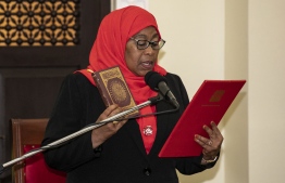 New Tanzanian President Samia Suluhu Hassan holds the Koran during the swearing-in ceremony as the country's first female President after the sudden death of President John Magufuli at statehouse in Dar es Salaam, Tanzania on March 19, 2021. - Hassan, 61, a soft-spoken Muslim woman from the island of Zanzibar, will finish Magufuli's second five-year term, set to run until 2025, after the sudden death of John Magufuli from an illness shrouded in mystery. (Photo by STR / AFP)