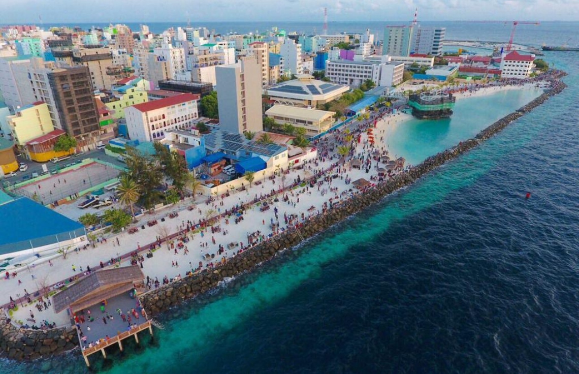 ޑރ. މުހައްމަދު މުއިއްޒު ހައުސިން މިނިސްޓަރު ކަމުގައި ހުންނެވި އިރު މާލޭގެ ހުޅަނގު ސަރަހައްދުން ބިން ހިއްކައިގެން ތަރައްގީ ކޮށްފައިވާ ރަސްފަންނު ސަރަހައްދު އެއްކޮށް ފެންނަހެން ނަގާފައިވާ ޑްރޯން ފޮޓޯއެއް. ރައީސް ޔާމީންގެ ވެރިކަމުގައި މާލެއަކީ ހިތްފަސޭހަ ސިޓީއަކަށް ހެދުމަށް ވަރަށް ބޮޑަށް މަސައްކަތް ކުރައްވައި ނަތީޖާ ނެރެދެއްވި.