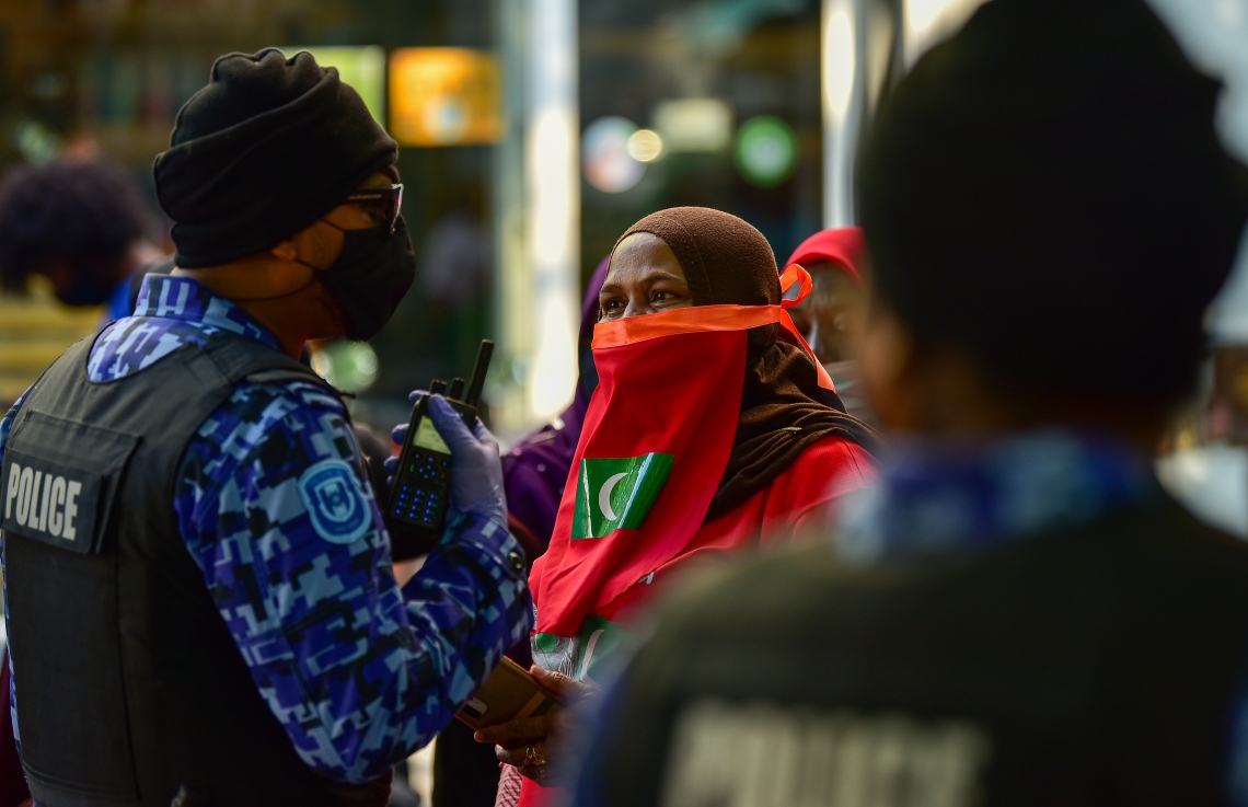 މާލެ، އޭޕްރީލް 2، 2021- އިދިކޮޅު ޕީޕީއެމް/ޕީއެންސީން މާލޭގައި މިއަދު ކުރި މުޒާހަރާ ހުއްޓުވަން އުޅުނު ފުލުހަކާ، މުޒާހަރާގެ ބައިވެރިއަކު ވާހަކަ ދައްކަނީ: މިއަދުގެ މުޒާހަރާގައި ވަނީ ކުޑަކުދިންނަށް ކުރާ ޖިންސީ އަނިޔާ އާއި ރޭޕްކުރުމާ ދެކޮޅަށް ސަރުކާރުން އެކަށީގެންވާ ފިޔަވަލުތައް ނާޅާ ކަމަށް ބުނެ އެކަން ބަދަލުކުރުމަށް އަޑު އުފުލާފައި.---ފޮޓޯ: އަހުމަދު އަވްޝަން/މިހާރު