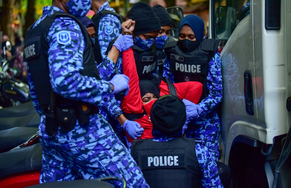 މާލެ، އޭޕްރީލް 2، 2021- އިދިކޮޅު ޕީޕީއެމް/ޕީއެންސީން މާލޭގައި މިއަދު ކުރި މުޒާހަރާގެ ތެރެއިން އަންހެނަކު ފުުލުހުންގެ ވެހިކަލަކަށް އަރުވަން މަސައްކަތް ކުރަނީ: މިއަދުގެ މުޒާހަރާގައި ވަނީ ކުޑަކުދިންނަށް ކުރާ ޖިންސީ އަނިޔާ އާއި ރޭޕްކުރުމާ ދެކޮޅަށް ސަރުކާރުން އެކަށީގެންވާ ފިޔަވަލުތައް ނާޅާ ކަމަށް ބުނެ އެކަން ބަދަލުކުރުމަށް އަޑު އުފުލާފައި.---ފޮޓޯ: އަހުމަދު އަވްޝަން/މިހާރު