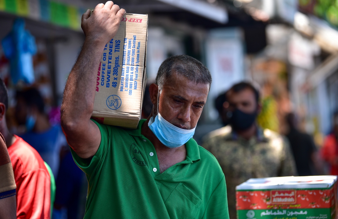 ރަށަކަށް ގެންދާ ފޮށިގަނޑެއް ލައިގެން މީހަކު ދަނީ: މާލޭގެ ބާޒާރުމަތި މި ދުވަސްވަރު ވަރަށް ބާރުބޮޑު. އަންނަ ހަފުތާގައި ރޯދަ މަސް ފަށާތީ ގިނަ އަދަދެއްގެ ދޯނިފަހަރު މިހާރު އޮތީ މާލޭ ފަޅުގައި -- ފޮޓޯ: އަހުމަދު އަވްޝަން/ މިހާރު