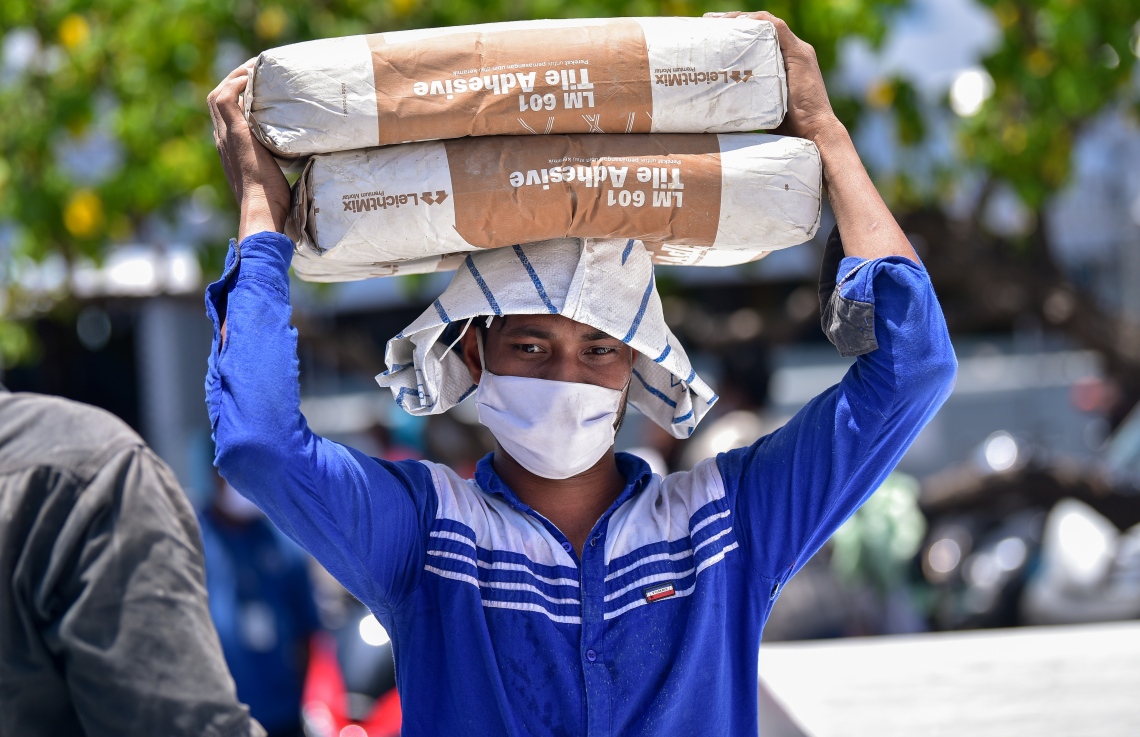 ރަށަކަށް ފޮނުވާ ސިމެންތި ބަސްތާތަކެއް މީހަކު އުފުލަނީ: ރޯދަ އަށް ތައްޔާރުވުމަށް ޓަކައި ގޭތެރެ ޒީނަތްތެރި ކުރުމަކީ ސަގާފީ ކަމެއް -- ފޮޓޯ: އަހުމަދު އަވްޝަން/ މިހާރު