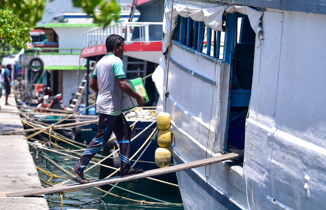 ރަށަކަށް ގެންދާ މުދާތަކެއް މީހަކު ބޯޓަކަށް އަރުވަނީ: އަންނަ ހަފުތާގައި ރޯދަ ފަށާނެ. ރަށްރަށަށް މުދާ ގެންދާ ވަރަށް ގިނަ އަދަދެއްގެ ބޯޓުފަހަރާއި ދޯނިތައް މިހާރު އޮތީ މާލޭ ފަޅުތެރޭގައި -- ފޮޓޯ: އަހުމަދު އަވްޝަން