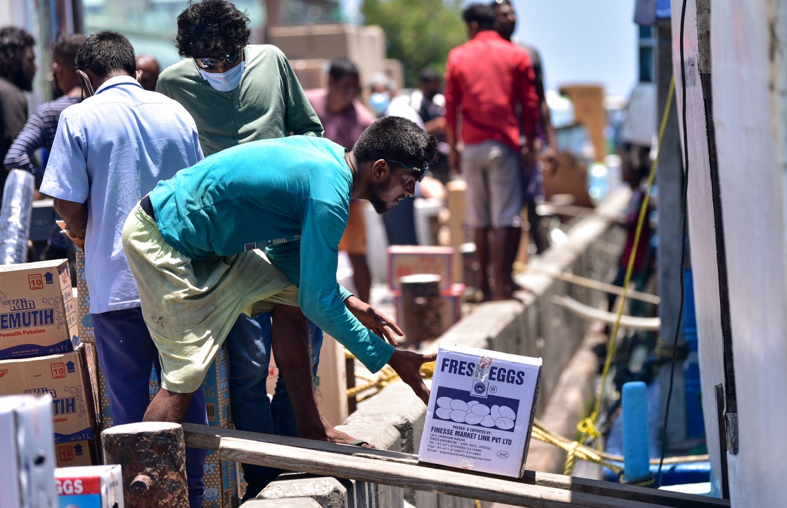 ރަށަކަށް ގެންދާ މުދާތަކެއް މީހަކު ބޯޓަކަށް އަރުވަނީ: އަންނަ ހަފުތާގައި ރޯދަ ފަށާނެ. ރަށްރަށަށް މުދާ ގެންދާ ވަރަށް ގިނަ އަދަދެއްގެ ބޯޓުފަހަރާއި ދޯނިތައް މިހާރު އޮތީ މާލޭ ފަޅުތެރޭގައި -- ފޮޓޯ: އަހުމަދު އަވްޝަން