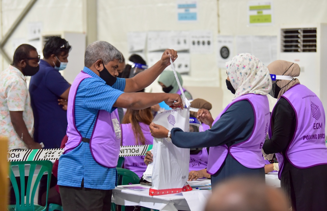 މާލެ: އޭޕްރިލް 10، 2021: މާލޭގައި ބަހައްޓާފައިވާ ވޯޓުފޮއްޓެއް ކައިރީގައި އޮފިޝަލުންތަކެއް ހަރަކާތްތެރިވަނީ.---ފޮޓޯ: ނިޝާން އަލީ/މިހާރު