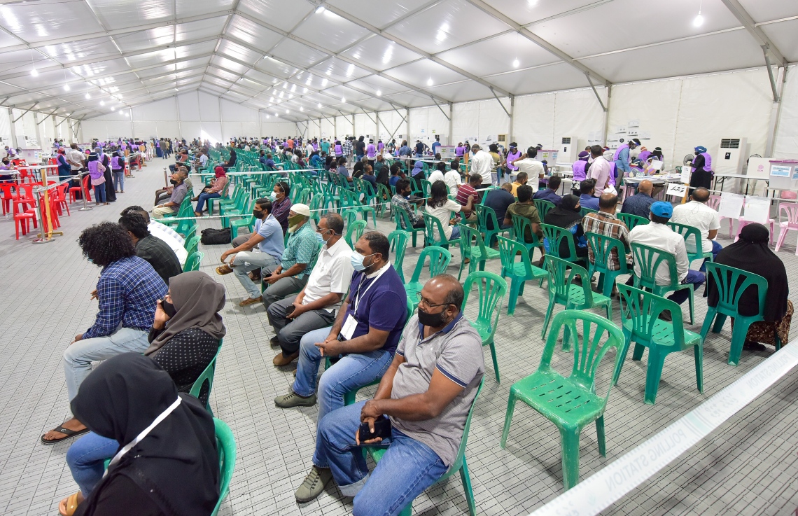 މާލެ: އޭޕްރިލް 10، 2021: ވޯޓުލުމަށް މާލޭގައި ހަދާފައިވާ ޓެންޓެއްގައި ވޯޓުލުމަށް ބަޔަކު ކިޔޫގައި މަޑުކޮށްލައިގެން.---ފޮޓޯ: ނިޝާން އަލީ/މިހާރު