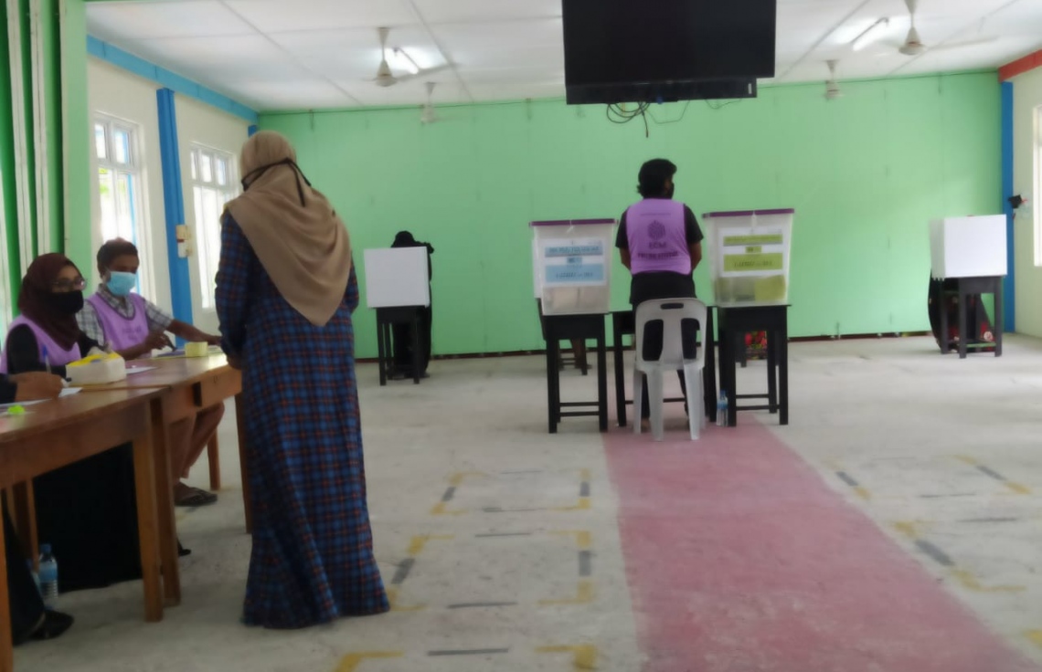 ރ. ހުޅުދުއްފާރު: އޭޕްރިލް 10، 2021: ހުޅުދުއްފާރުގައި ބަހައްޓާފައިވާ ވޯޓުފޮއްޓަކަށް މީހަކު ވޯޓުލަނީ.---ފޮޓޯ: މުހައްމަދު ނަސީމް