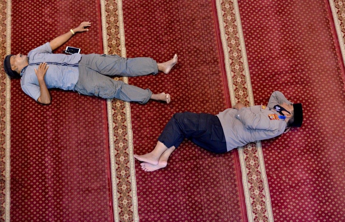 އިންޑޮނީޝިއާ: އޭޕްރިލް 16، 2021: ރޯދައަށް ތިބި ދެ މީހަކު ނަމާދު ކުރުމަށްފަހު، މިސްކިތުގައި އޮށޯވެލައިގެން.-- ފޮޓޯ: އޭއެފްޕީ