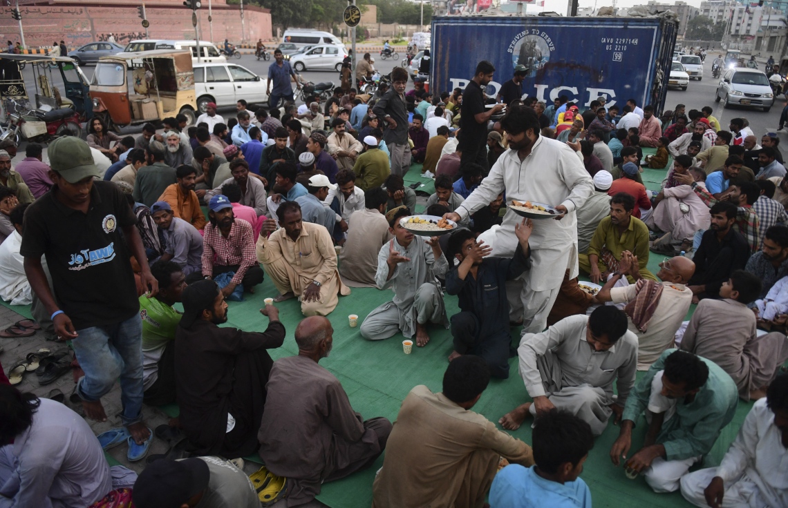 ޕާކިސްތާން: އޭޕްރިލް 17، 2021: އަވާޒް ވެލްފެއާގެ ނަމުގައި މަސައްކަތްކުރާ ބަޔަކު ރޯދަ ވީއްލުމަށް މީހުންނަށް ކާނާގެ އެހީ ފޯރުކޮށްދެނީ.-- ފޮޓޯ: އޭއެފްޕީ